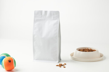 Dry Pet Food Bag Placed Next to a Bowl of Kibble and Colorful Toys in a Minimalist Setting