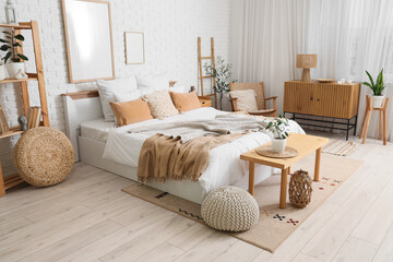 Interior of cozy bedroom with big bed, wooden bench and ladder