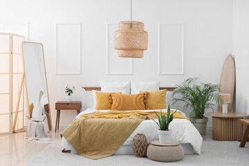 Interior of light bedroom with big bed, mirror and tables