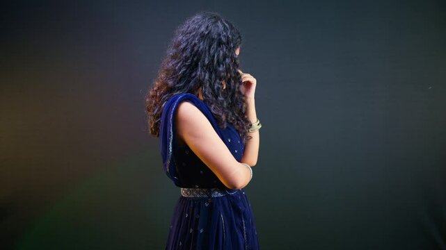 Woman in ethnic attire gazes down smiling gently