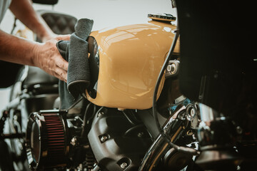 Biker man cleaning motorcycle , Polished and coating wax on fuel tank. repair and maintenance motorcycle concept.