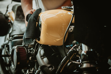 Biker man cleaning motorcycle , Polished and coating wax on fuel tank. repair and maintenance...