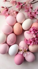   A cluster of pink and white eggs rests atop a pristine white table alongside a Pink bloom from a nearby tree