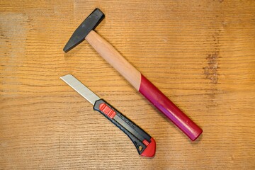 Power and Precision: Hammer and Utility Knife on Wood