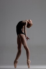 Young beautiful ballerina is posing in studio