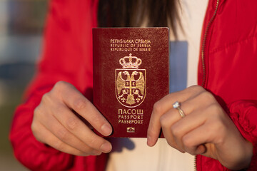 Serbian Biometric Passport ih hands of young woman traveler