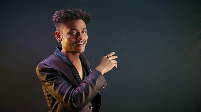 Smiling young man in suit signals toward upper spot