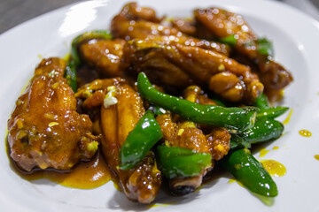 Spicy and sweet chicken wings with green peppers.