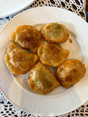 A plate of fried pierogi dumplings.