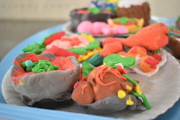 Colorful clay food models displayed on plate, showcasing creativity and vibrant details