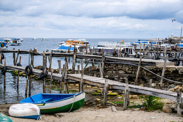 Obraz premium Scenic View of the Wooden Pier at the Port of Copacabana Bolivia with Boats Floating on the Calm Waters of Lake Titicaca Under a Clear Sky