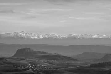 Stunning mountain landscape with snow capped peaks and valleys under a cloudy sky at dusk