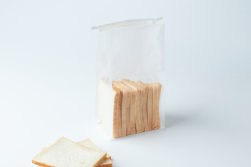 Slices of White Bread Neatly Packed in a Plastic Bag With Some Slices Placed Beside It
