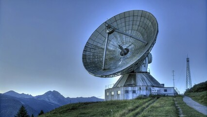 Tech meets nature: satellite dish against scenic mountains