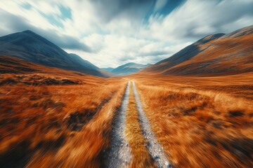 Obraz premium Beautiful winding path through colorful highland landscape under a dramatic sky in the afternoon light