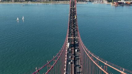 The 25 April bridge (Ponte 25 de Abril) located in Lisbon, Portugal, crossing the Targus river. Drone. 4k