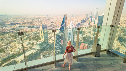 Tourist enjoying breathtaking panoramic views of Riyadh's skyline, featuring the iconic modern...