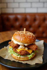 A crispy chicken burger delight. Golden fried perfection in a bun. Melted cheddar adds rich flavor. Special sauce enhances every bite. A cozy setting completes the experience