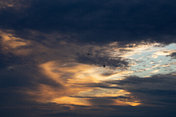 Beautiful dark colorful dramatic sky with clouds at sunset or sunrise.