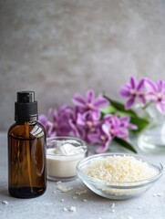 A serene arrangement featuring a dark glass bottle, creamy substance, salt, and vibrant purple flowers, evoking a sense of relaxation and spa-like tranquility.