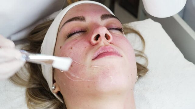 Young woman receiving modern facial low-voltage electrical treatment to stimulate elastin and collagen production for facial muscles improvement. Most popular face lifting treatment. Cosmetician work.
