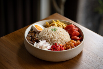 Delicious rice bowl with meat, vegetables, and egg, served in round dish. colorful and appetizing meal that showcases variety of textures and flavors