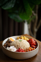 delicious bowl of rice with various accompaniments including vegetables, fried chicken, and garnishes, showcasing vibrant and appetizing meal