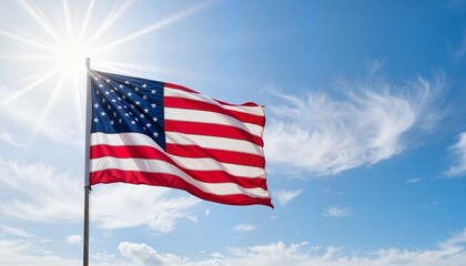 Obraz premium Waving American flag against bright blue sky, patriotic symbolism