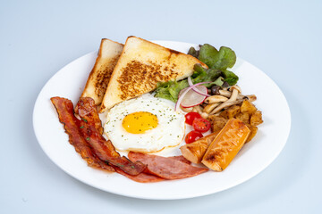 Delicious breakfast plate featuring toast, fried egg, bacon, vegetables, and mushrooms, perfect for hearty meal to start day
