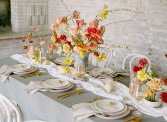 Stunning floral centerpiece decorates an elegant dining table for a special gathering in a cozy indoor setting