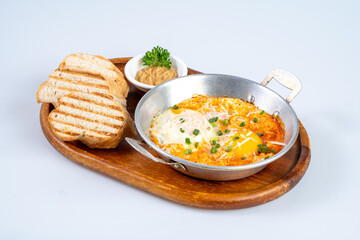 Delicious baked eggs served in skillet with toast and side of spread. Perfect for breakfast or brunch, this dish combines flavors and textures for satisfying meal