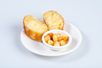 Freshly baked bread rolls served with crispy croutons on white plate, perfect for cozy meal. Enjoy delightful combination of textures and flavors