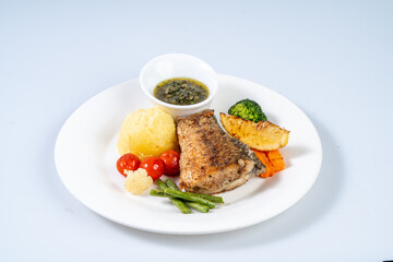 Delicious grilled fish served with mashed potatoes, vegetables, and sauce