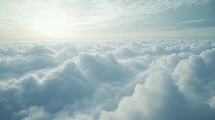 Naklejka premium Above the Clouds: A breathtaking aerial view of a sea of fluffy, white clouds stretching endlessly towards the horizon under a bright sky.