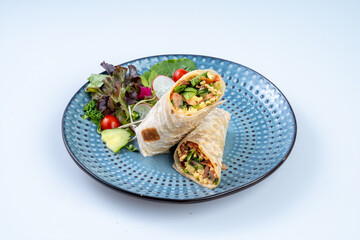 Delicious wrap filled with fresh vegetables and herbs, served with side salad. colorful and healthy meal option perfect for any occasion