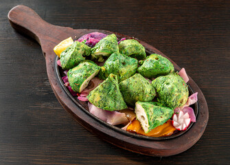 Pudina Tikka traditional Indian cuisine dish with Marinated Chicken Chunks with yogurt, mint and spices. seen up close and isolated on a dark wood background