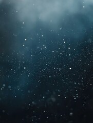 Fototapeta premium Celestial Dance: Captivating image of tiny glowing particles scattered against a moody, atmospheric blue background, reminiscent of a starlit night sky or underwater scene.