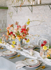 Elegant floral centerpiece adorns a beautifully set dining table for an intimate gathering in a modern venue