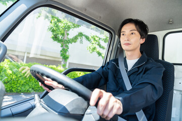 トラックを運転する若い男性