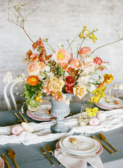 Elegant floral arrangement decorates a beautifully set dining table for a spring gathering