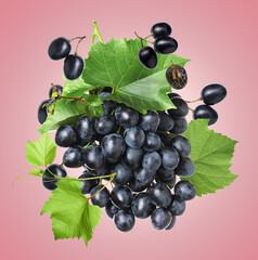Fresh grapes in air on pink background
