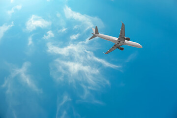 Airplane flying in beautiful blue sky with clouds