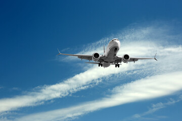 Airplane flying in beautiful blue sky with clouds