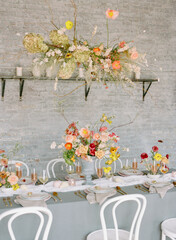 Elegant table setting adorned with vibrant floral arrangements in a modern dining space during daytime