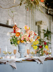 Elegant dining table decorated with vibrant flowers and delicate glassware in a charming venue