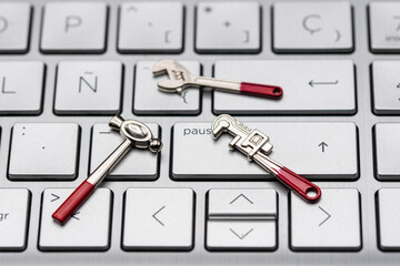Herramientas en miniatura sobre el teclado de un ordenador a modo de reparación
