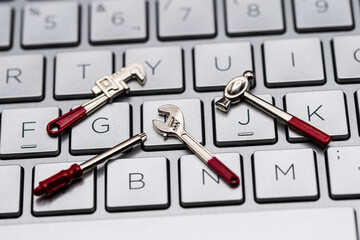 Herramientas en miniatura sobre el teclado de un ordenador a modo de reparación