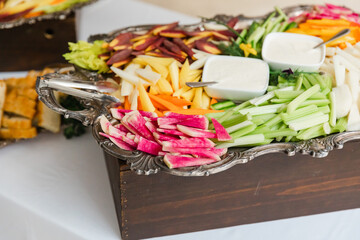 Colorful assortment of fresh vegetables and fruits served at a festive gathering during daytime