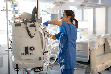 nurse setting up hemofiltration machine in the icu