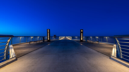 The new Prerow pier on the Baltic Sea in the blue hour. The illuminated handrails form a beautiful line towards the centre of the picture.